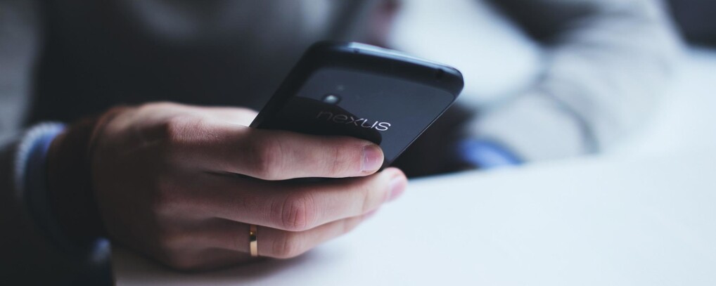 Hånd på mobiltelefon