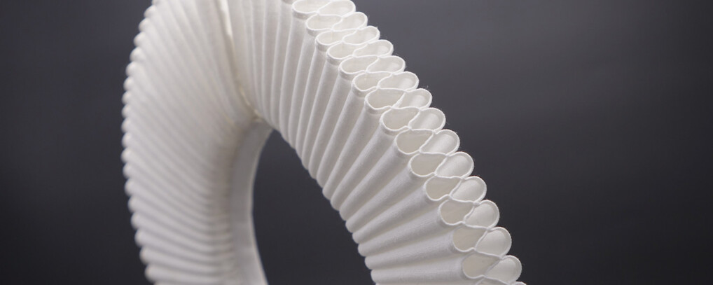 Nærbillede af hvid præstekrave på mærk baggrund.