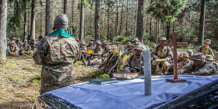 Værnspræst holder gudstjeneste i skov med soldater